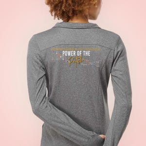 May include: Gray long-sleeve shirt with a colorful graphic on the back that says "POWER OF THE Patch".