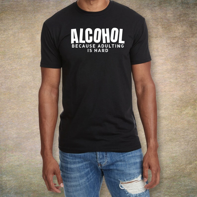May include: A black t-shirt with white text that reads "ALCOHOL BECAUSE ADULTING IS HARD".