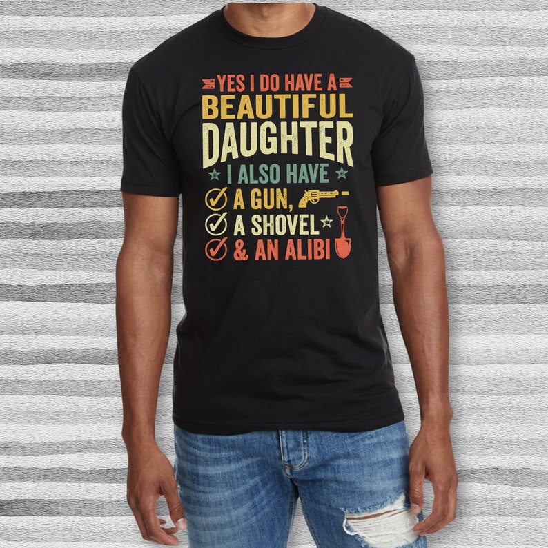 May include: A black t-shirt with a vintage-style graphic that reads "Yes I do have a beautiful daughter. I also have a gun, a shovel, and an alibi."