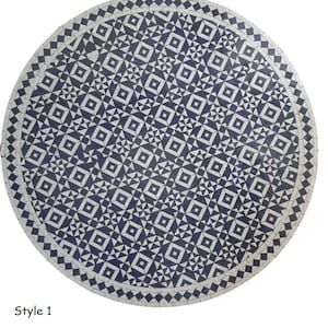 Pode incluir: Um tampo de mesa redondo de mosaico de azulejos brancos e azuis com um padrão geométrico. O tampo da mesa tem aproximadamente 76 cm de diâmetro.