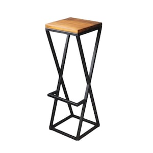 Puede incluir: Taburete de bar moderno con asiento cuadrado de madera y estructura de metal negro. El marco presenta un diseño en forma de X para las patas y un reposapiés. El taburete mide aproximadamente 76 cm de alto.