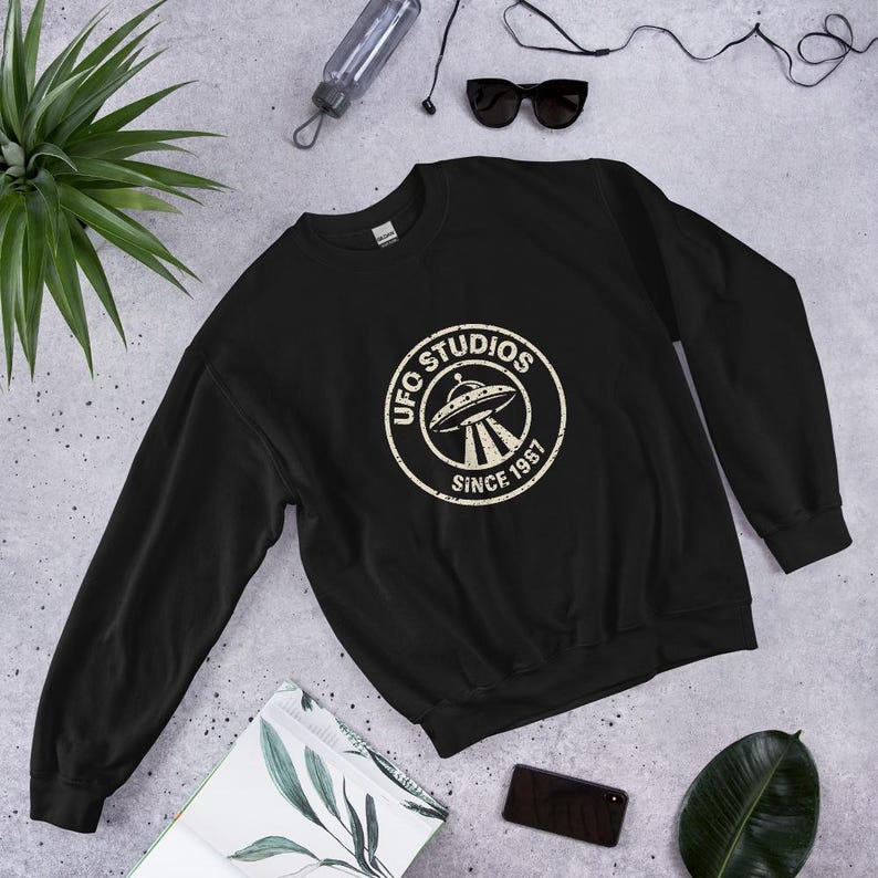 Official UFO Studios Crewneck Sweatshirt | Distressed Since 1987 Flying Saucer Seal | Black Unisex Pullover
