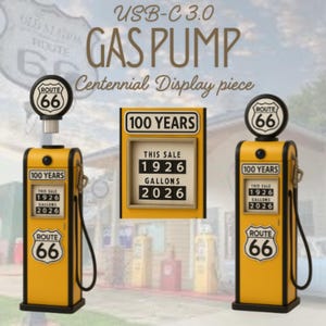 以下が含まれることがあります： Route 66のロゴが入った黄色と黒のUSB-C 3.0ガソリンポンプ型ディスプレイ。本体正面には100 YEARS、THIS SALE 1926、GALLONS 2026と記載されています。上部には円形のRoute 66看板があり、黒い燃料ホースが付属しています。