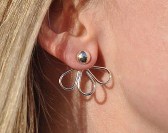 May include: Silver flower-shaped earrings with a round silver stud in the center.