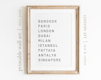 May include: A framed printable wall art print with the text "printable wall art | miss pudú" on the left side and "custom art | text & colors" on the right side. The print features a list of cities in black text: Bangkok, Paris, London, Dubai, Milan, Istanbul, Pattaya, Antalya, Singapore.
