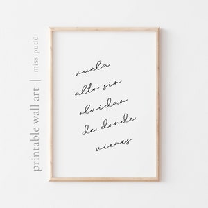 May include: A framed print with the Spanish text "vuela alto sin olvidar de donde vienes" which translates to "fly high without forgetting where you come from".