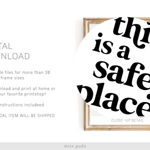 May include: A printable wall art design with a white background and black text that reads "this is a safe place". The design is framed in a light wood frame.