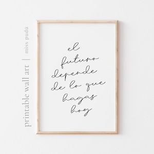 以下が含まれることがあります： 「el futuro depende de lo que hagas hoy」というテキストがエレガントな黒い筆記体で書かれたフレームプリント。プリントは明るい木製のフレームに入っており、「printable wall art」と「miss pudú」とラベルされています。