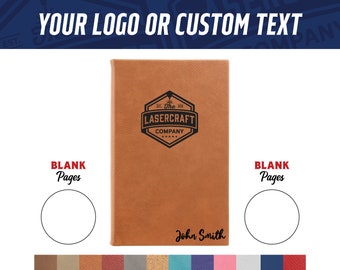 May include: A brown leather-bound journal with a black logo that says "The Lasercraft Company" and a blank page for personalization. The journal has a blank page on the left and right sides. The text "John Smith" is printed on the front cover.