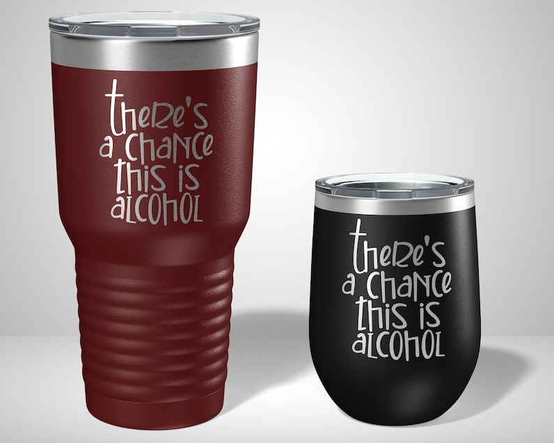 May include: Two stainless steel tumblers with a burgundy and black finish. The tumblers feature a white inscription that reads "there's a chance this is alcohol".