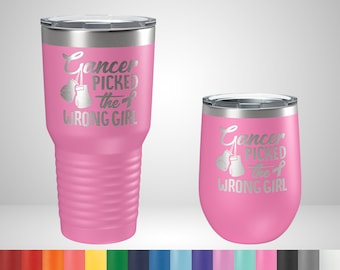 Puede incluir: Dos vasos rosas aislados: un vaso alto y una copa de vino sin pie. Ambos tienen el texto plateado "Cancer Picked the Wrong Girl" con guantes de boxeo y una cinta. El vaso es alto.