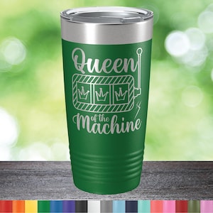 May include: Green stainless steel tumbler with a white design that says "Queen of the Machine" with a slot machine graphic.