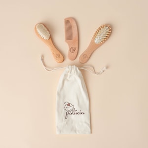 Puede incluir: Un conjunto de tres cepillos y peines para bebés de madera en una bolsa de cordón blanco con el logotipo "palucia". Los cepillos y peines están hechos de madera natural y tienen cerdas suaves y naturales.
