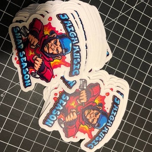May include: A stack of white stickers with a cartoon illustration of a monkey wearing a red hoodie, blue hat, and holding a microphone. The text "5 HIGH MUSIC" and "SNAP SEASON" are on the sticker.
