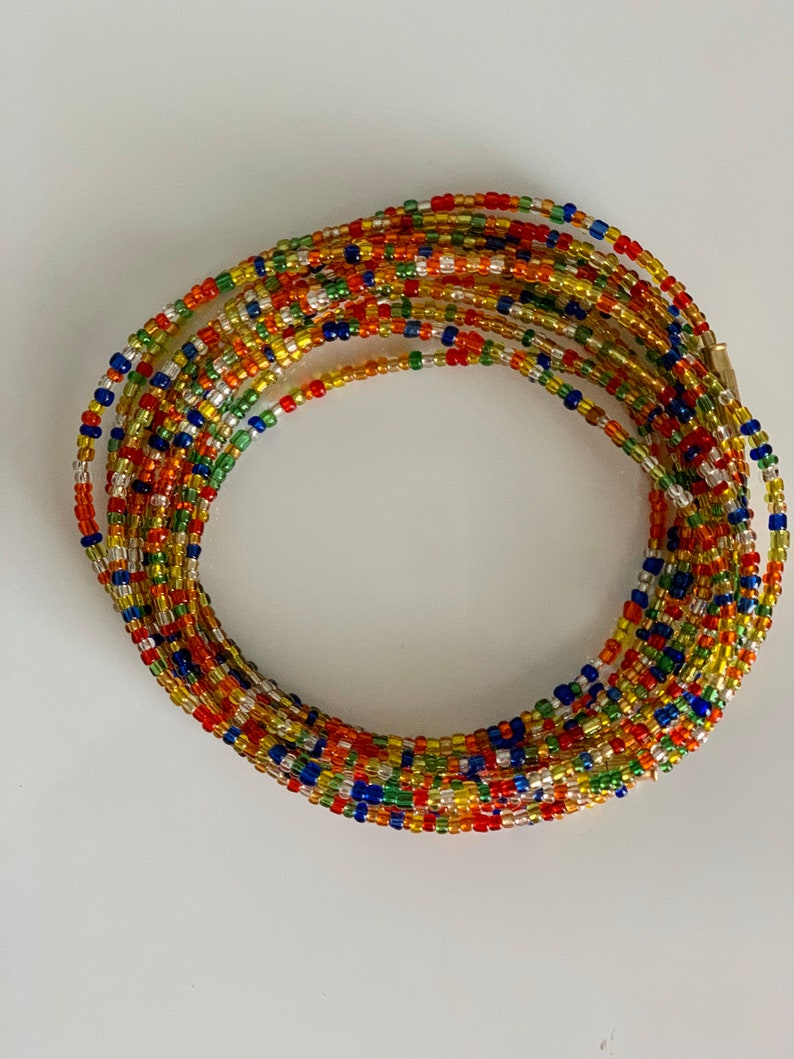 May include: A colourful beaded waist chain with a variety of colours including red, orange, yellow, green, blue, and silver.