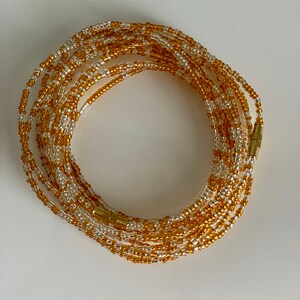 May include: A gold and white beaded waist chain with a magnetic clasp.