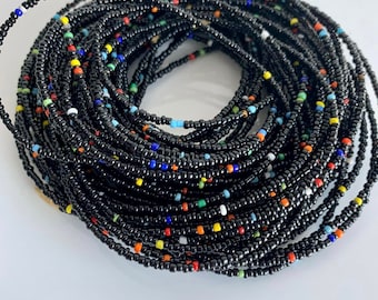 May include: A black beaded waist bead string with colorful accents. The beads are small and tightly strung together, creating a long, continuous strand.