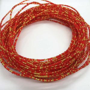May include: A red and gold beaded waist chain. The chain is made of small, round beads that are strung together in a continuous loop. The beads are a mix of red and gold, creating a vibrant and eye-catching design.