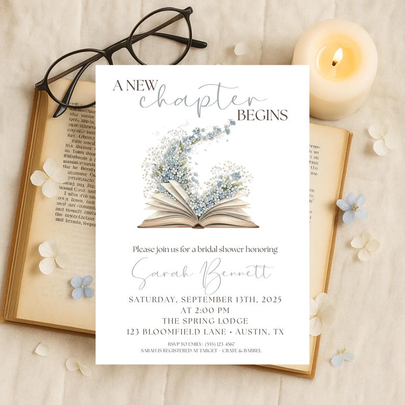 May include: A bridal shower invitation with the text "A New Chapter Begins." The invitation features an open book with floral accents and event details. A lit candle, glasses, and an open book are also in the image.