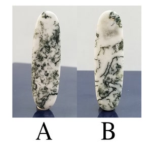 May include: Two oval-shaped agate cabochons with a white base and green dendritic patterns. The cabochons are labeled A and B.