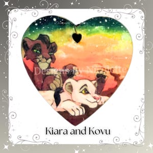 May include: A heart-shaped painting of Simba and Nala's children, Kiara and Kovu, from Disney's The Lion King II: Simba's Pride. The painting is done in a watercolor style with a colorful background of orange, yellow, and green.