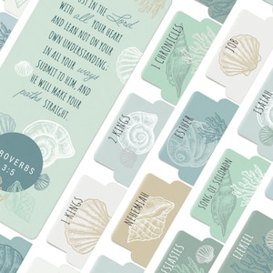 May include: A set of teal and beige bookmarks with a seashell and coral design. Each bookmark features a different book of the Bible, including Proverbs, 1 Kings, 2 Kings, 1 Chronicles, Esther, Song of Solomon, Isaiah, Jeremiah, Ezekiel, Daniel, and Jonah.