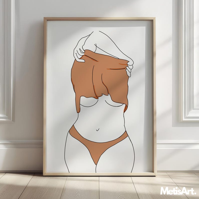 May include: A framed art print featuring a minimalist line drawing of a figure partially obscured by a brown garment. The artwork depicts a person in a nude-colored bikini, with the upper body and arms in outline. The print is in a light-colored wooden frame.