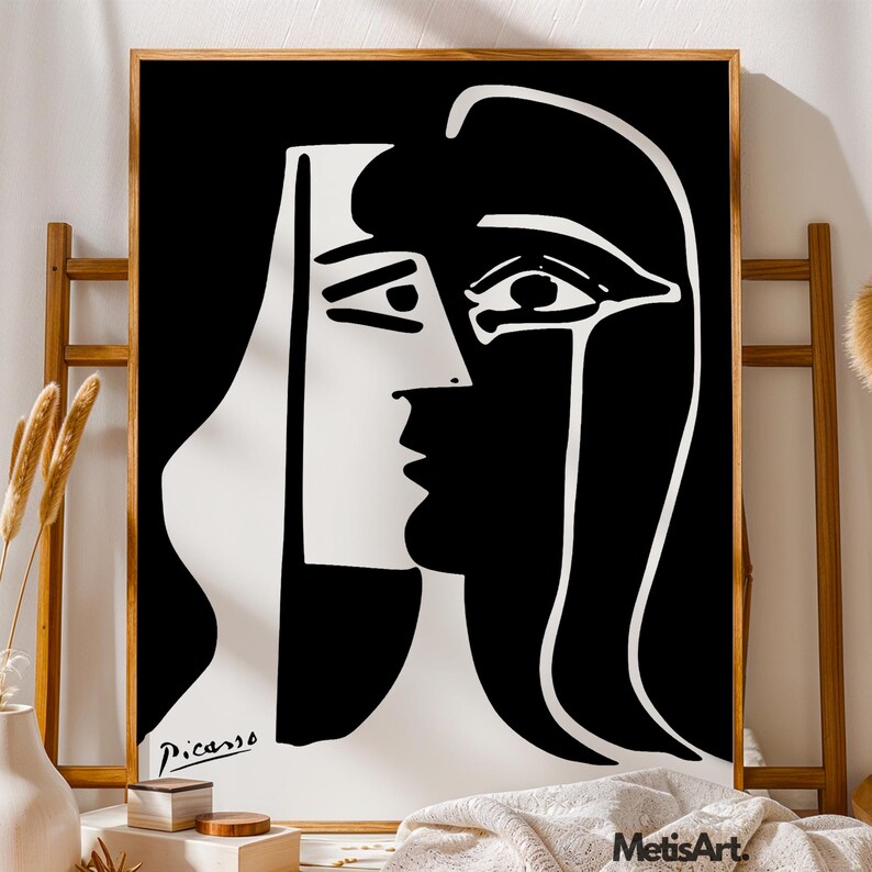 May include: A black and white framed art print featuring a high-contrast, abstract portrait of a face in a cubist style. The image displays bold, simplified lines and shapes with the signature Picasso printed in the bottom left corner.