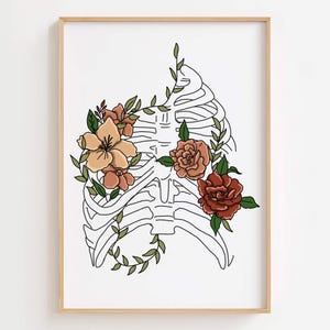 Puede incluir: Una impresi&oacute;n art&iacute;stica enmarcada que presenta un dibujo lineal negro de una caja tor&aacute;cica adornada con flores coloridas y hojas verdes. Las flores son en tonos melocot&oacute;n, naranja y rojo, sobre un fondo blanco.
