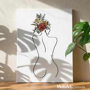 May include: A rectangular canvas print featuring a black line art drawing of a person's back. The figure has a cluster of colorful flowers and greenery in shades of red, orange, yellow, and green resting on their head. The text MetisArt.canvas is visible.