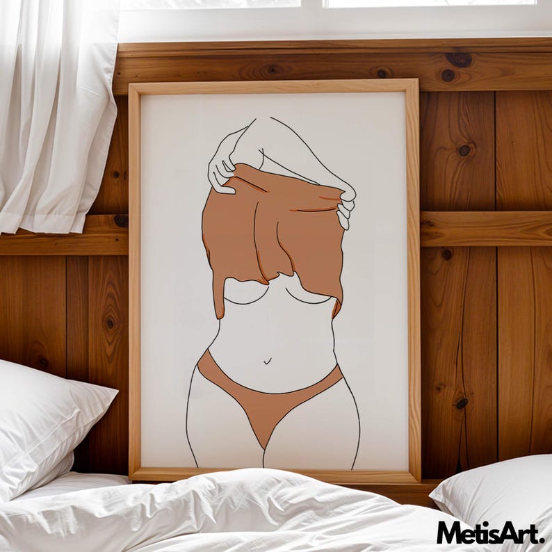 May include: A framed art print featuring a minimalist line drawing of a person partially undressing. The figure is depicted in a neutral color palette of brown and beige, with a wooden frame. The artwork is set against a white background.