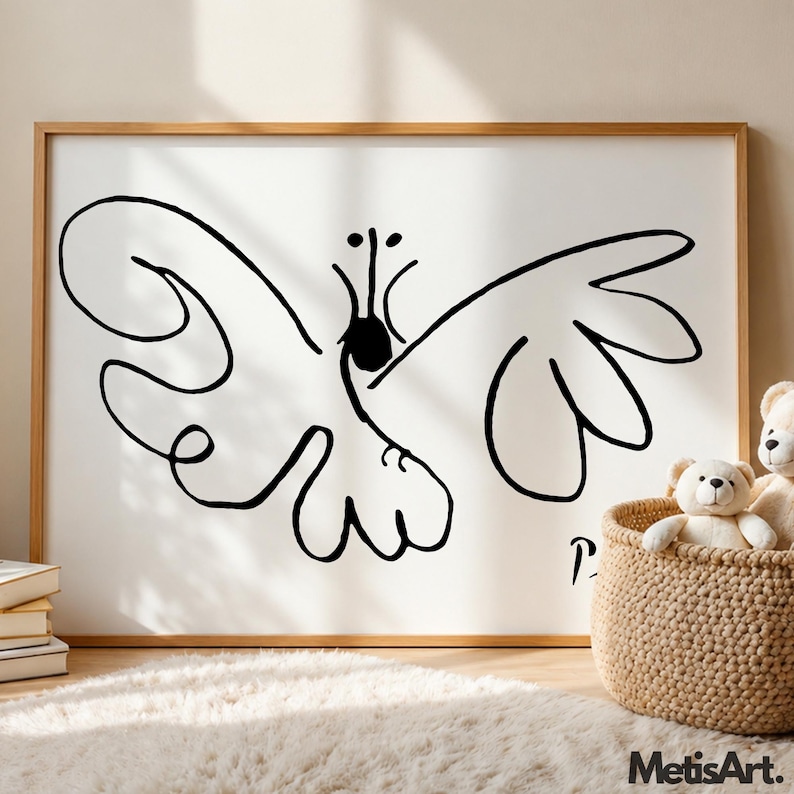 May include: A framed wall art print featuring a black line drawing of a butterfly on a white background. The artwork includes a signature in the bottom right corner. The frame is made of light-colored wood, and the print is displayed horizontally.