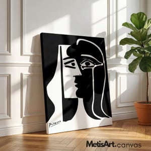 May include: A black and white canvas print featuring a high-contrast abstract portrait in a cubist style. The artwork displays a stylized face with bold lines and shapes, signed with the name Picasso in the bottom left corner of the rectangular piece.