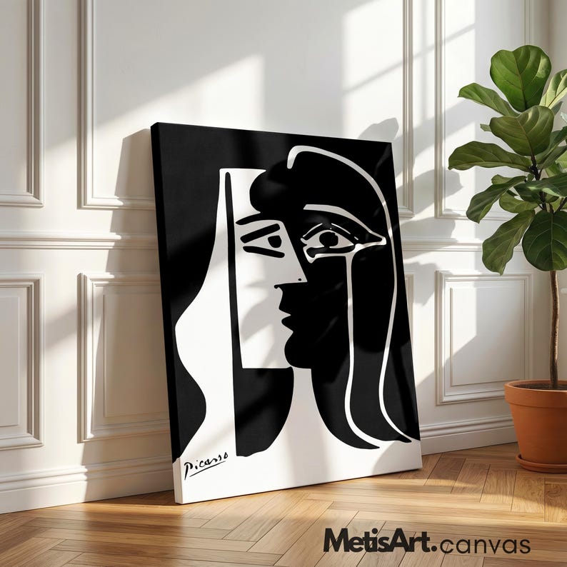 May include: A black and white canvas print featuring a high-contrast abstract portrait in a cubist style. The artwork displays a stylized face with bold lines and shapes, signed with the name Picasso in the bottom left corner of the rectangular piece.