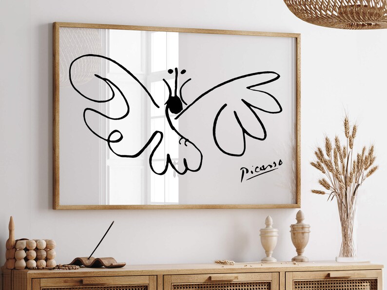 May include: A rectangular wall art print in a light wood frame featuring a black line drawing of a butterfly on a white background. The artwork includes the signature Picasso in black ink in the bottom right corner of the print area.