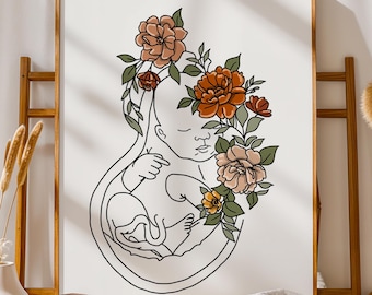 May include: A framed wall art print featuring a black line drawing of a fetus inside a womb shape, surrounded by stylized flowers in shades of orange, peach, and sage green. The text MetisArt is printed in the bottom right corner of the print.