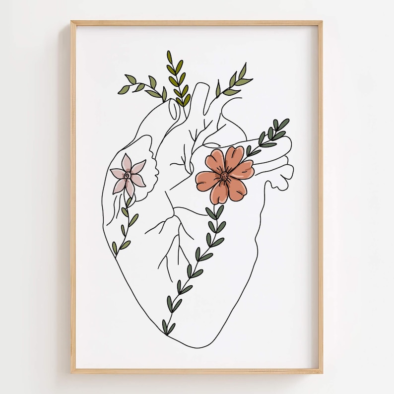 Puede incluir: Una impresi&oacute;n art&iacute;stica enmarcada que presenta un dibujo lineal de un coraz&oacute;n humano adornado con flores y vegetaci&oacute;n. El coraz&oacute;n est&aacute; delineado en negro, con flores rosas y melocot&oacute;n y hojas verdes. La obra de arte est&aacute; sobre un fondo blanco.