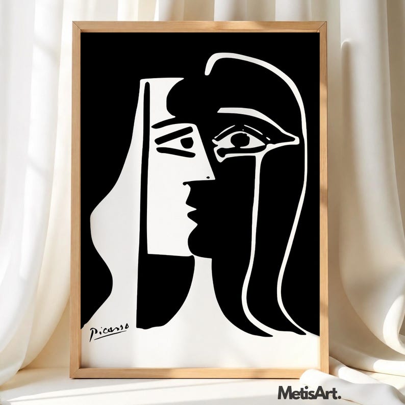 May include: A framed black and white print featuring a stylized, abstract portrait of a face with bold, contrasting lines. The artwork displays a split-face composition with a signature reading Picasso in the bottom left corner and MetisArt text.