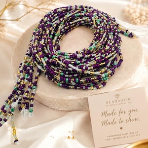 May include: A coiled strand of waist beads featuring a repeating pattern of deep purple, metallic gold, bright turquoise, and translucent white glass seed beads. A square card is included with the text BEADBUTIK, Made for you. Made to shine.