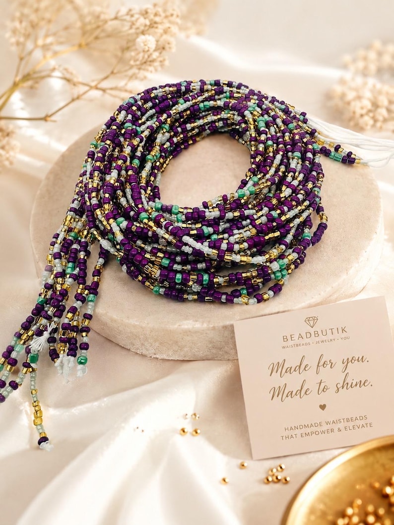 May include: A coiled strand of waist beads featuring a repeating pattern of deep purple, metallic gold, bright turquoise, and translucent white glass seed beads. A square card is included with the text BEADBUTIK, Made for you. Made to shine.