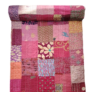 Puede incluir: Una colcha de retazos hecha de varias telas en tonos de rosa, morado y dorado. La colcha está cosida a mano y tiene un aspecto vintage único.