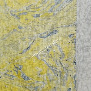 May include: A yellow and gray kantha quilt with a white border. The quilt has a marbled pattern and is made of recycled saris.
