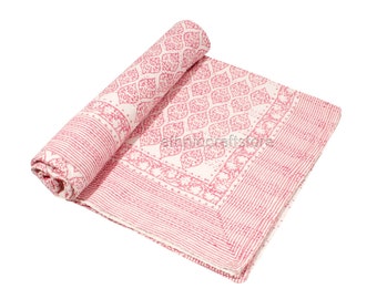May include: A pink and white cotton quilt with a floral pattern. The quilt is rolled up and has a pink border.