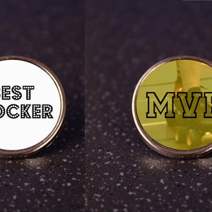 May include: Two silver pins with black text. The first pin is white with the text "BEST BLOCKER". The second pin is gold with the text "MVP" and a blurry image of a person's leg wearing roller skates.
