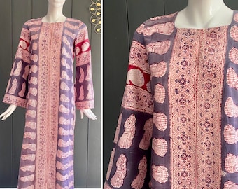 May include: A long, purple and red printed cotton dress with a square neckline and long bell sleeves. The dress features a traditional Indian block print design.