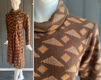 May include: A brown and orange geometric patterned turtleneck dress with a tie belt. The dress is made of a soft, knitted fabric.