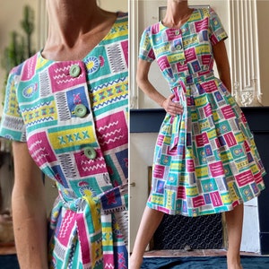 Vintage-Kleid aus den 50er/60er Jahren mit kurzen, taillierten und dann ausgestellten Ärmeln, aus farbechter Baumwolle, weiß mit bunten Mustern T 34/36