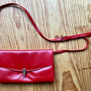 Ravissant sac en cuir rouge vintage 60s forme pochette à bandoulière réglable, intérieur noir à soufflets 3 compartiments