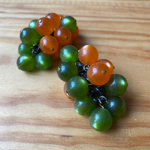 Clips d’oreilles vintage 60s forme grappe avec enfilade de perles de résine opalescentes vertes et orangées