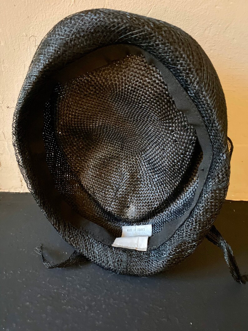 Vintage 60s black fine straw mini hat covered with a net and adorned with clever aerial volutes T 55